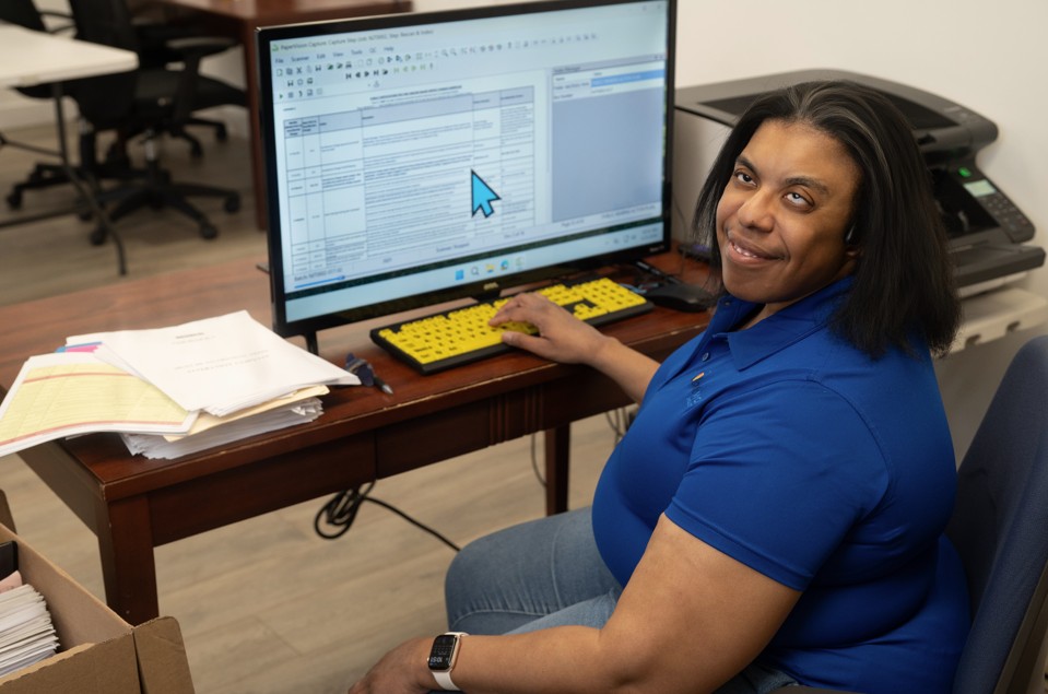 bestwork dsdi worker jamilla sitting at her desk