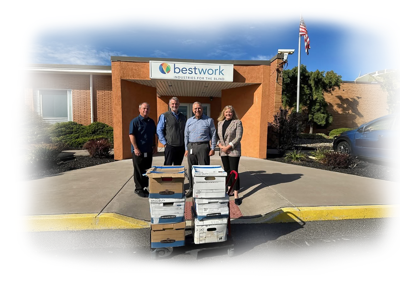 Bestwork Industries for the Blind building, four people standing in front of a cart with stacked boxes