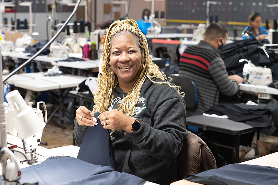 Woman smiling while working on a sewing machine